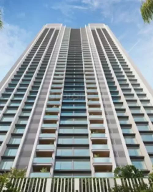 Modern high-rise residential apartment building with symmetrical balconies and glass windows against a clear blue sky – BrandLand.