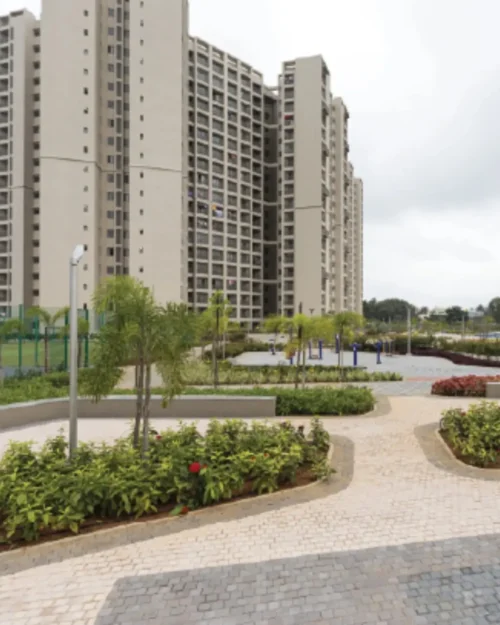 Outdoor BTL activation setup in a landscaped residential complex with modern high-rise buildings and branded activity zones.
