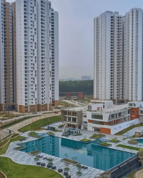 Outdoor BTL activation setup in a landscaped residential complex with modern high-rise buildings and branded activity zones.