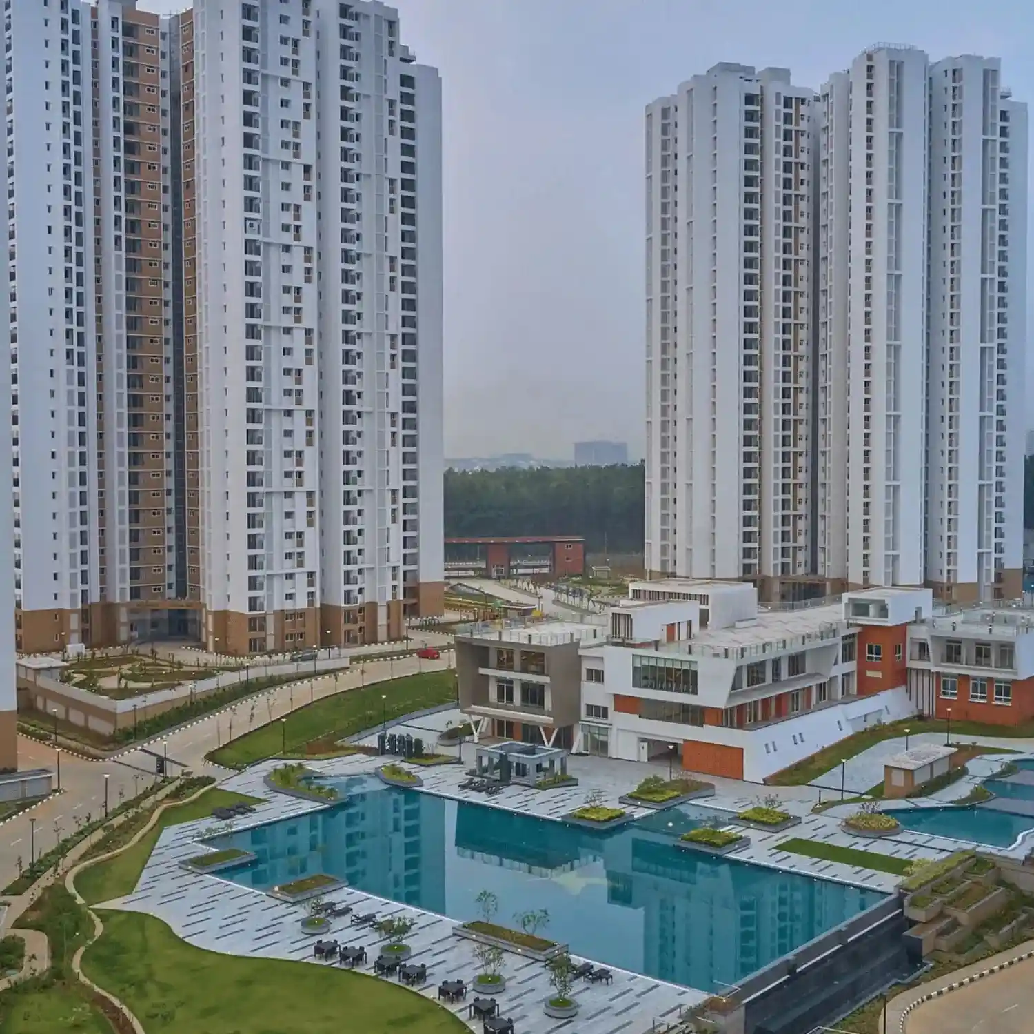 Outdoor BTL activation setup in a landscaped residential complex with modern high-rise buildings and branded activity zones.